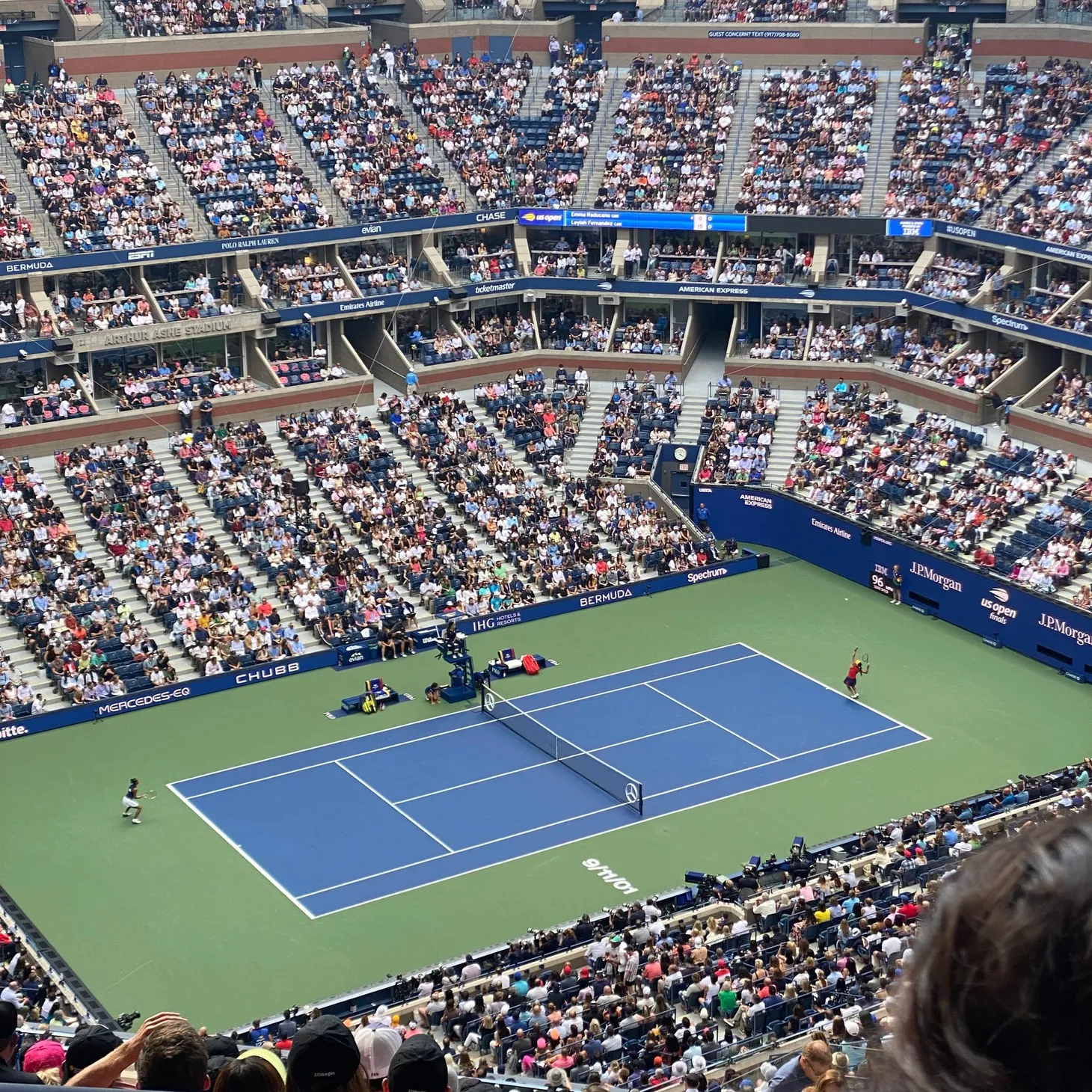 a photo of a packed stadium and a tennis court, Emma Raducanu and Leylah Fernandez in Arthur Ashe for the 2021 US Open women's final